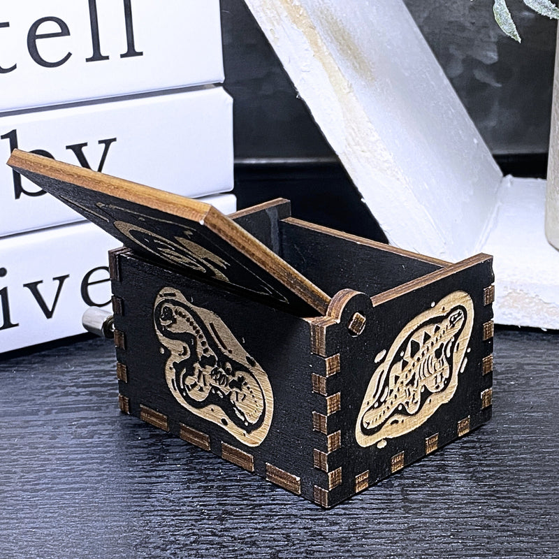 Load image into Gallery viewer, Jurassic Park: Join Alan Grant, Ellie Sattler, and Ian Malcolm on a tour of an island theme park filled with genetically resurrected dinosaurs. Get ready for an adventure with our iconic music box by MarketPlaceFad - Malaura Ashley.
