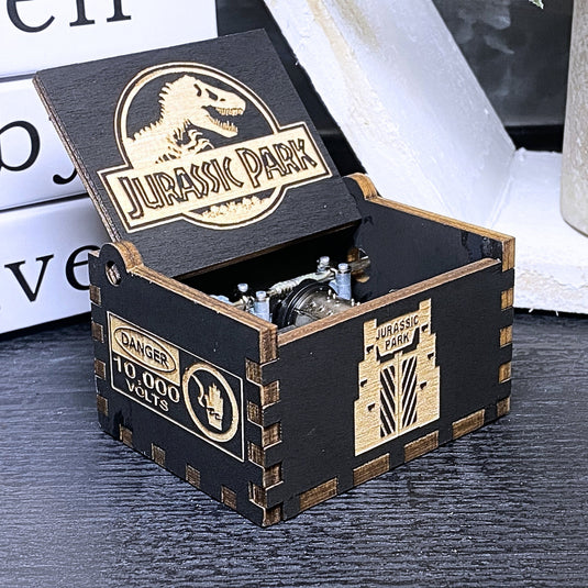 Jurassic Park: Join Alan Grant, Ellie Sattler, and Ian Malcolm on a tour of an island theme park filled with genetically resurrected dinosaurs. Get ready for an adventure with our iconic music box by MarketPlaceFad - Malaura Ashley.