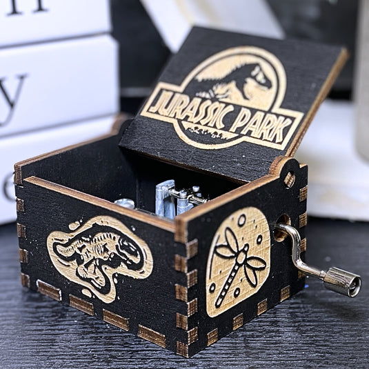 Jurassic Park: Join Alan Grant, Ellie Sattler, and Ian Malcolm on a tour of an island theme park filled with genetically resurrected dinosaurs. Get ready for an adventure with our iconic music box by MarketPlaceFad - Malaura Ashley.