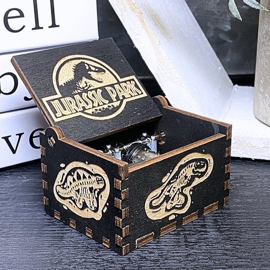 Jurassic Park: Join Alan Grant, Ellie Sattler, and Ian Malcolm on a tour of an island theme park filled with genetically resurrected dinosaurs. Get ready for an adventure with our iconic music box by MarketPlaceFad - Malaura Ashley.