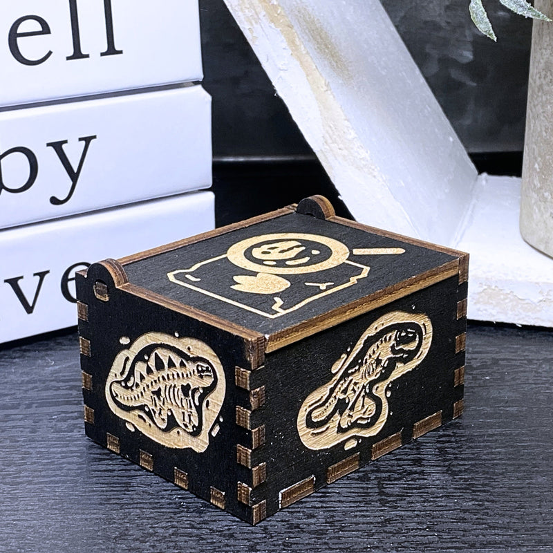 Load image into Gallery viewer, Jurassic Park: Join Alan Grant, Ellie Sattler, and Ian Malcolm on a tour of an island theme park filled with genetically resurrected dinosaurs. Get ready for an adventure with our iconic music box by MarketPlaceFad - Malaura Ashley.
