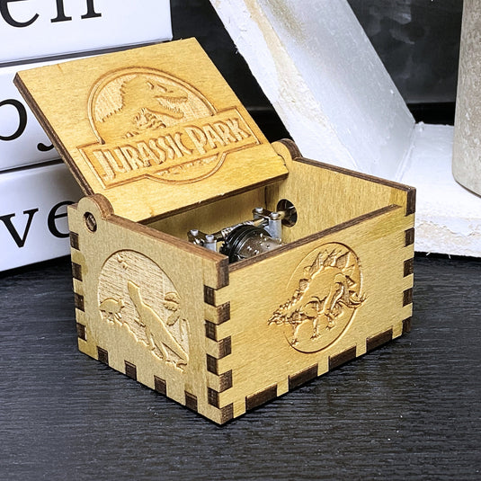 Jurassic Park: Join Alan Grant, Ellie Sattler, and Ian Malcolm on a tour of an island theme park filled with genetically resurrected dinosaurs. Get ready for an adventure with our iconic music box by MarketPlaceFad - Malaura Ashley.