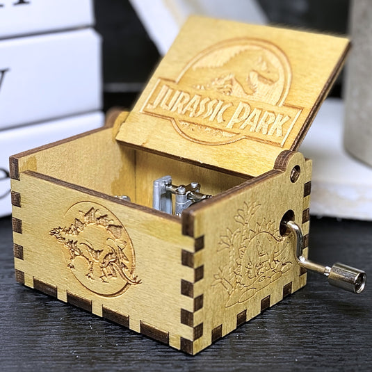 Jurassic Park: Join Alan Grant, Ellie Sattler, and Ian Malcolm on a tour of an island theme park filled with genetically resurrected dinosaurs. Get ready for an adventure with our iconic music box by MarketPlaceFad - Malaura Ashley.