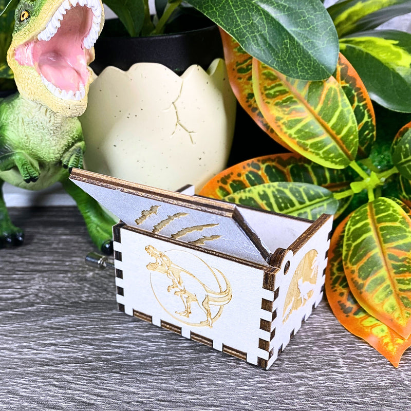 Load image into Gallery viewer, Jurassic Park: Join Alan Grant, Ellie Sattler, and Ian Malcolm on a tour of an island theme park filled with genetically resurrected dinosaurs. Get ready for an adventure with our iconic music box by MarketPlaceFad - Malaura Ashley.
