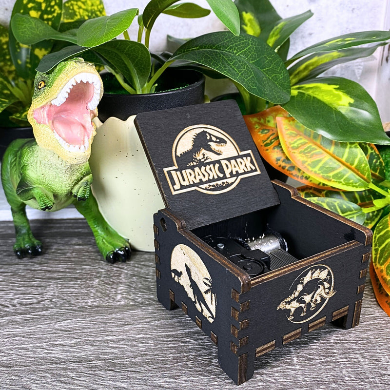 Load image into Gallery viewer, Jurassic Park: Join Alan Grant, Ellie Sattler, and Ian Malcolm on a tour of an island theme park filled with genetically resurrected dinosaurs. Get ready for an adventure with our iconic music box by MarketPlaceFad - Malaura Ashley.
