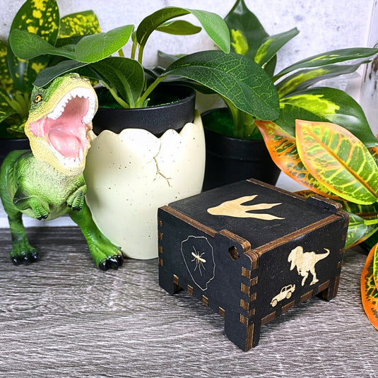 Jurassic Park: Join Alan Grant, Ellie Sattler, and Ian Malcolm on a tour of an island theme park filled with genetically resurrected dinosaurs. Get ready for an adventure with our iconic music box by MarketPlaceFad - Malaura Ashley.