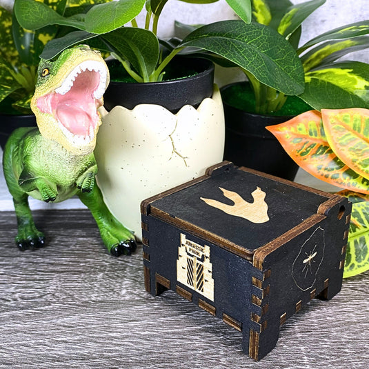 Jurassic Park: Join Alan Grant, Ellie Sattler, and Ian Malcolm on a tour of an island theme park filled with genetically resurrected dinosaurs. Get ready for an adventure with our iconic music box by MarketPlaceFad - Malaura Ashley.