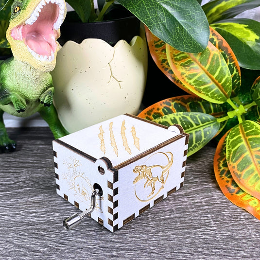 Jurassic Park: Join Alan Grant, Ellie Sattler, and Ian Malcolm on a tour of an island theme park filled with genetically resurrected dinosaurs. Get ready for an adventure with our iconic music box by MarketPlaceFad - Malaura Ashley.
