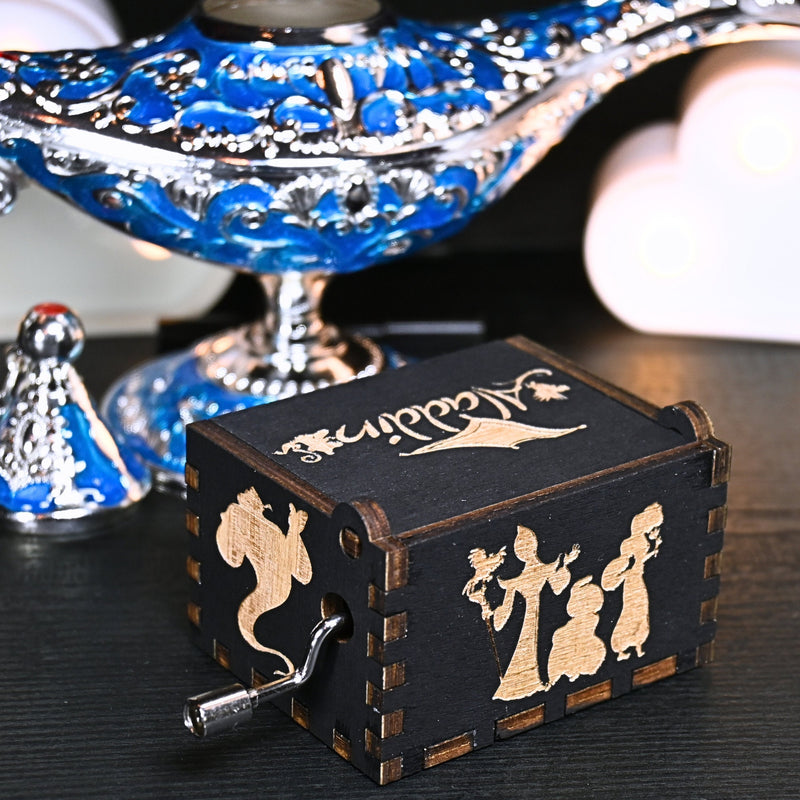 Load image into Gallery viewer, The Aladdin music box features intricate designs that capture the essence of the classic tale, including Aladdin and Princess Jasmine flying on the magic carpet. Its stunning design and enchanting melody make it the perfect gift for any occasion.
